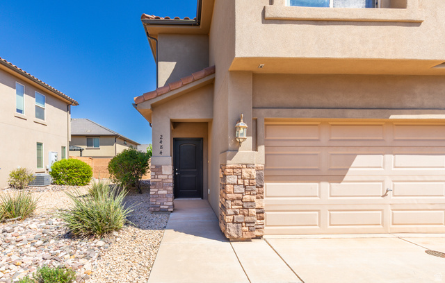 2484 Manzoni Road Santa Clara, UT 84765 - Photo 11 of 27 Property entrance with a garage, a tile roof, stucco siding, stone siding, and driveway