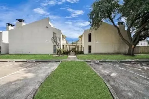 a view of a white house with a yard and a large tree