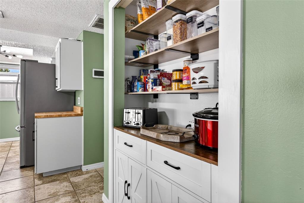 7325 Neva Lane Port Richey, FL 34668 - Photo 13 of 36 a kitchen with a refrigerator and cabinets