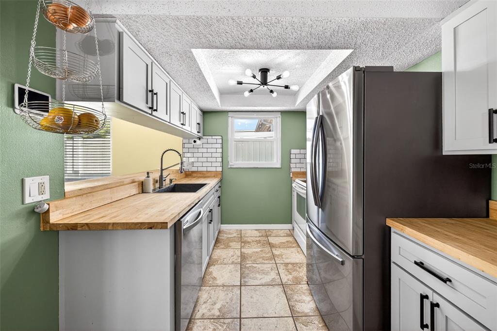 7325 Neva Lane Port Richey, FL 34668 - Photo 16 of 36 a kitchen with stainless steel appliances granite countertop a refrigerator and a sink