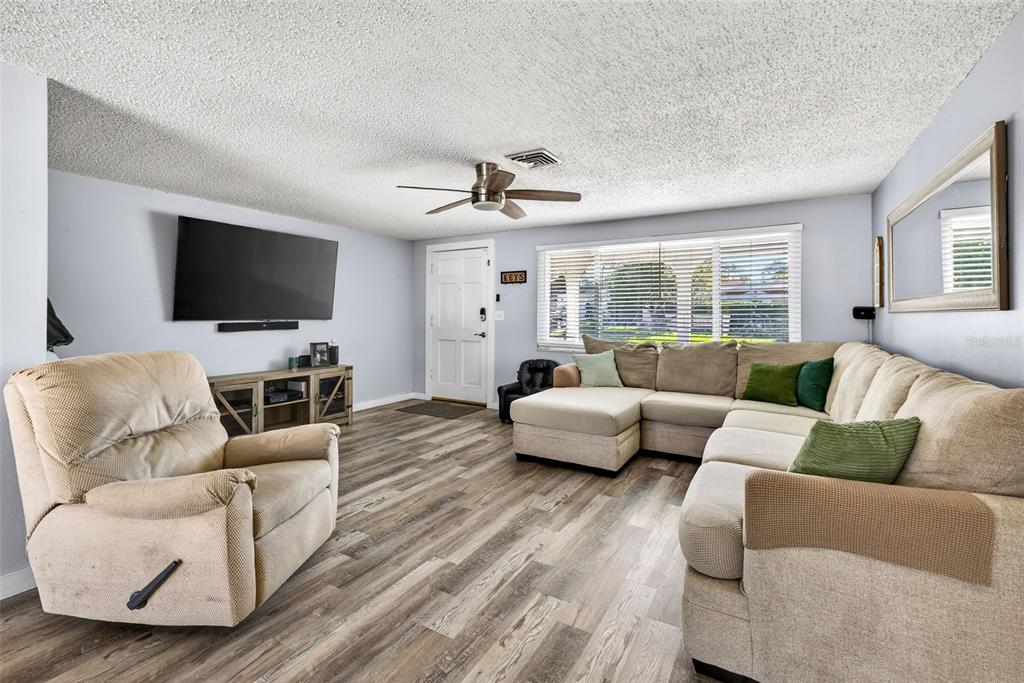 7325 Neva Lane Port Richey, FL 34668 - Photo 2 of 36 a living room with furniture flat screen tv and a large window