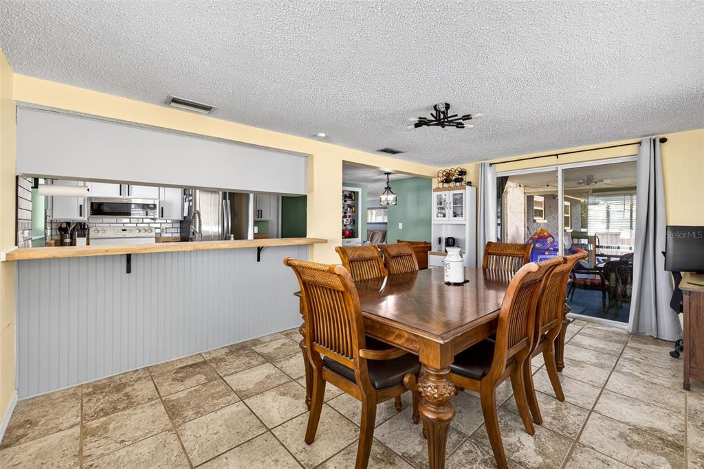 7325 Neva Lane Port Richey, FL 34668 - Photo 23 of 36 a dining room with stainless steel appliances kitchen island granite countertop a dining table chairs and granite counter tops