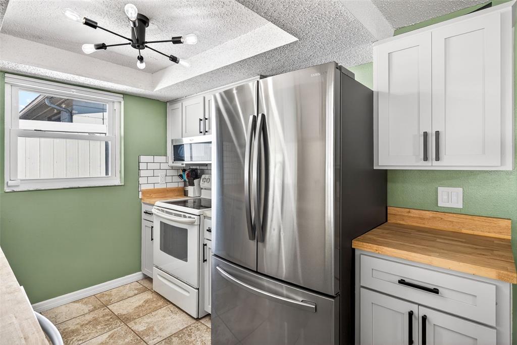 7325 Neva Lane Port Richey, FL 34668 - Photo 5 of 36 a kitchen with stainless steel appliances a refrigerator sink and cabinets