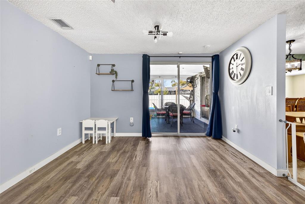 7325 Neva Lane Port Richey, FL 34668 - Photo 7 of 36 a view of a hallway with wooden floor and a dining room