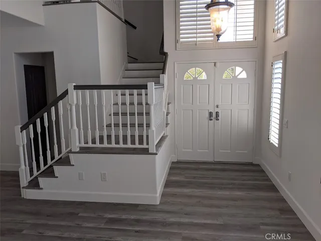 a view of a hallway with wooden floor and staircase