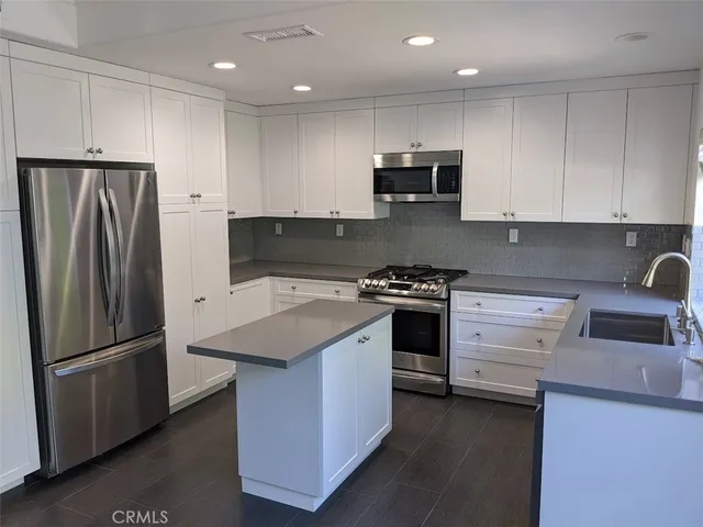 a kitchen with stainless steel appliances a stove microwave and refrigerator