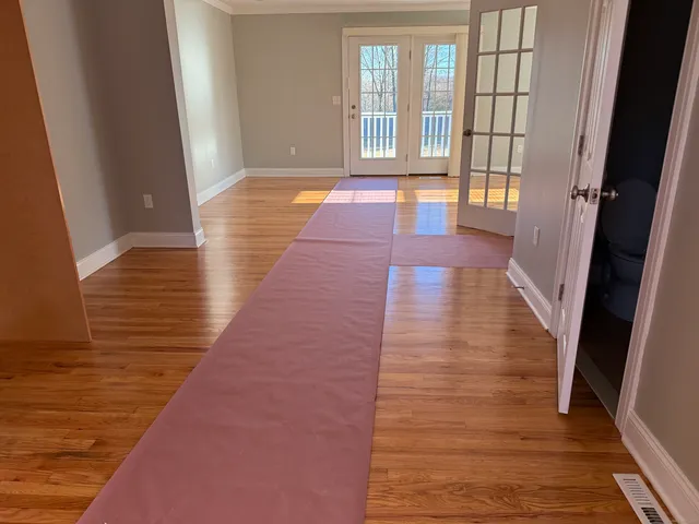 a view of a hallway with wooden floor and staircase