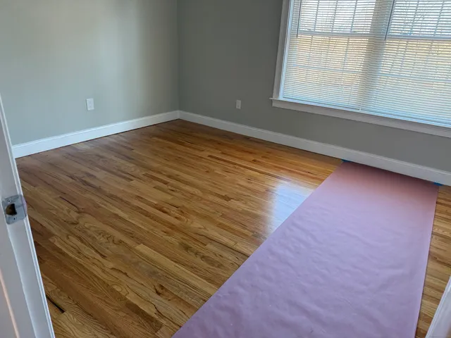 a view of wooden floor and windows in a room