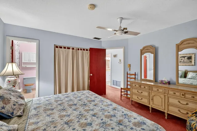 a bedroom with a bed dresser and wooden floor