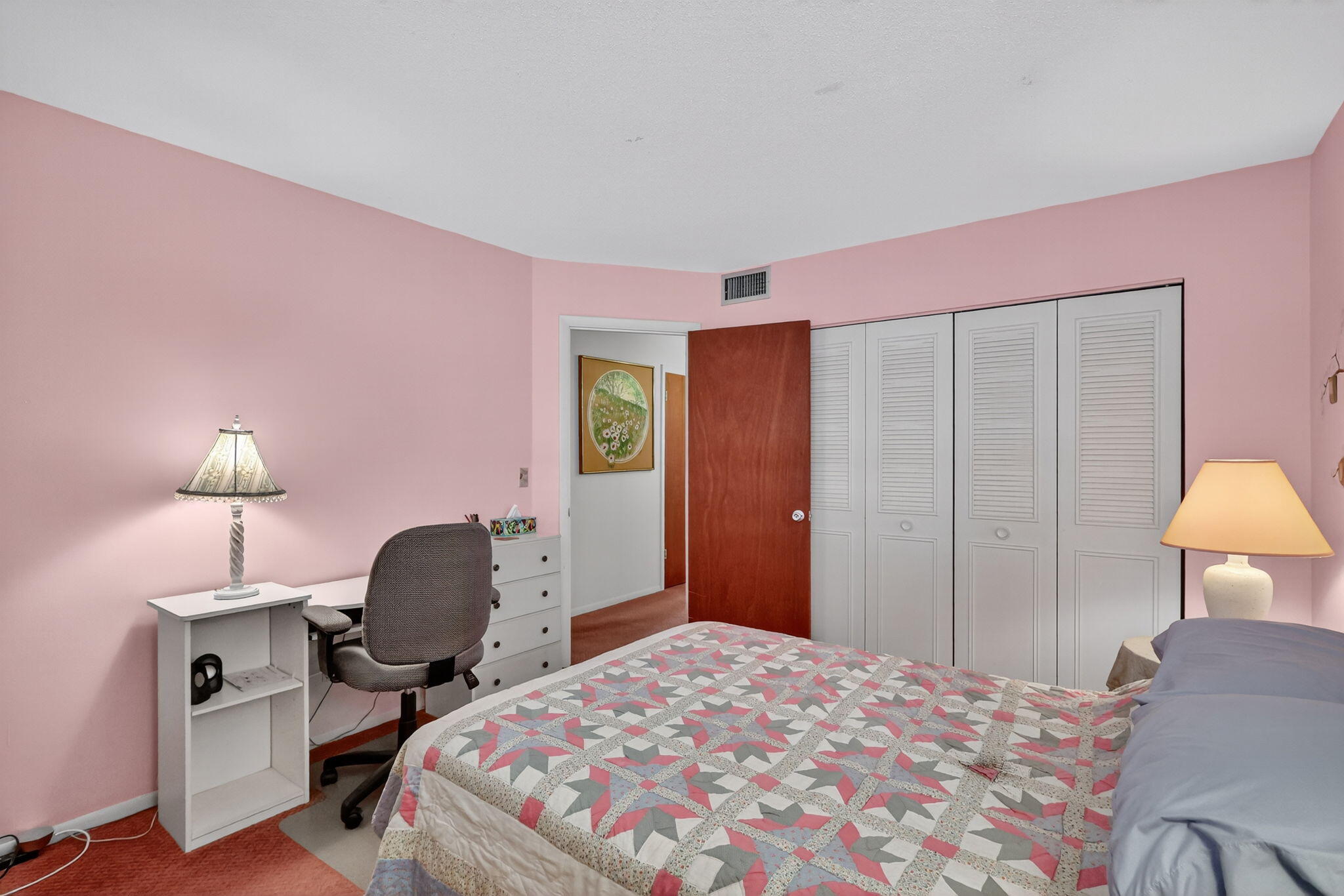 2929 Southeast Ocean Boulevard, Unit J10 Stuart, FL 34996 - Photo 22 of 29 a bedroom with a bed a desk and chair