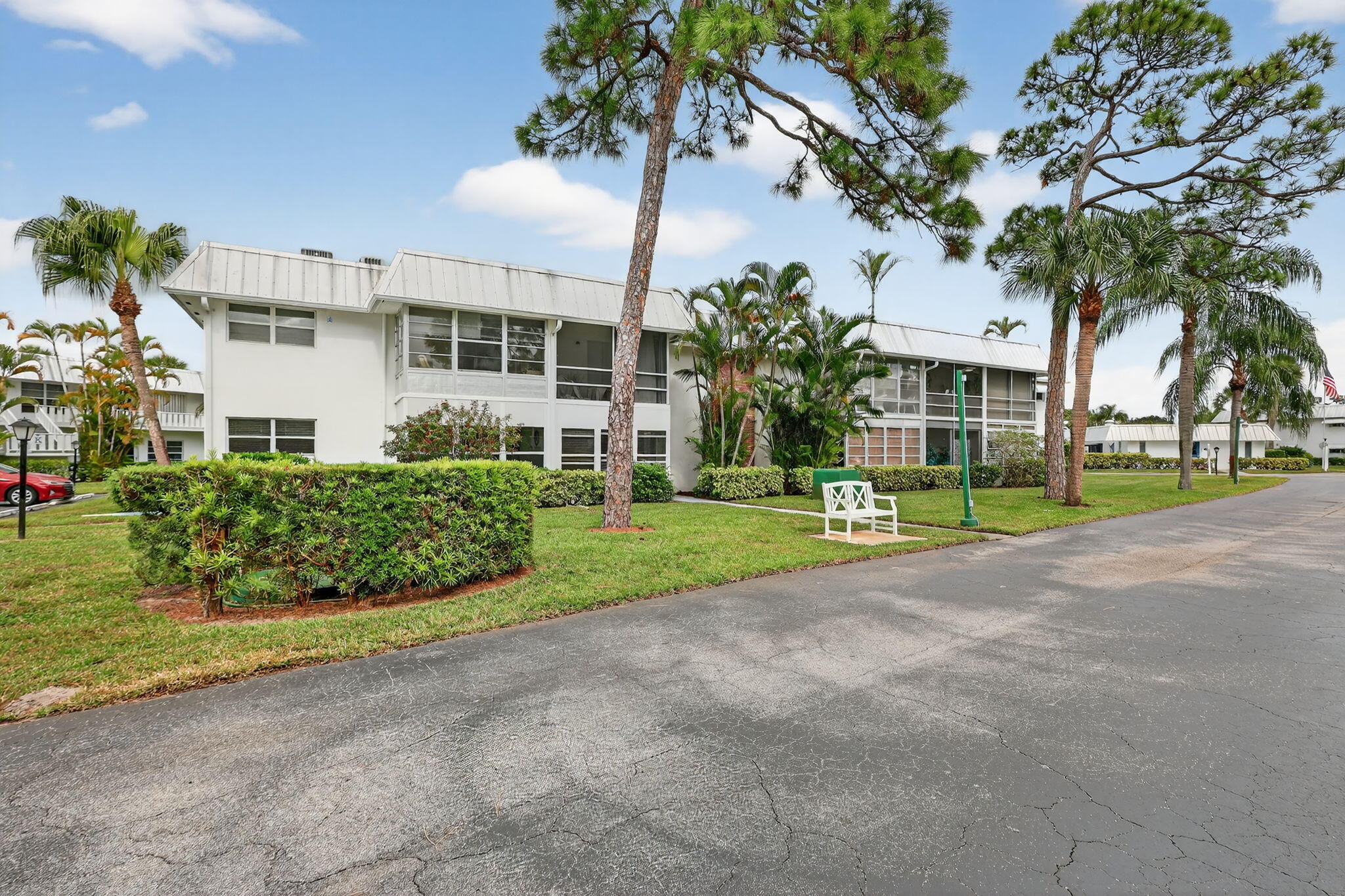 2929 Southeast Ocean Boulevard, Unit J10 Stuart, FL 34996 - Photo 27 of 29 a view of a house with a yard and palm trees