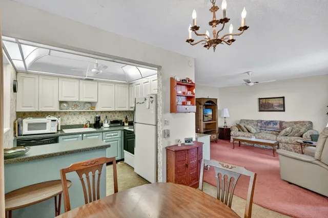 a living room with stainless steel appliances furniture and a kitchen view
