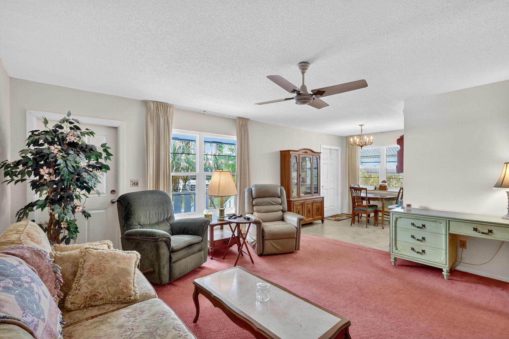 2929 Southeast Ocean Boulevard, Unit J10 Stuart, FL 34996 - Photo 5 of 29 a living room with furniture ceiling fan and a window