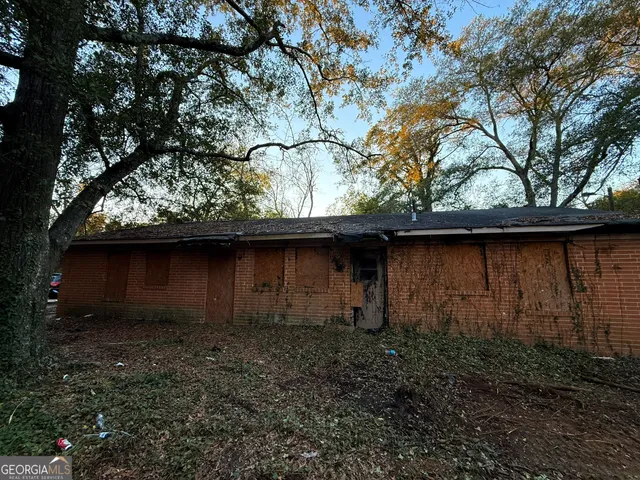 a backyard of a house with lots of plants and wooden fence