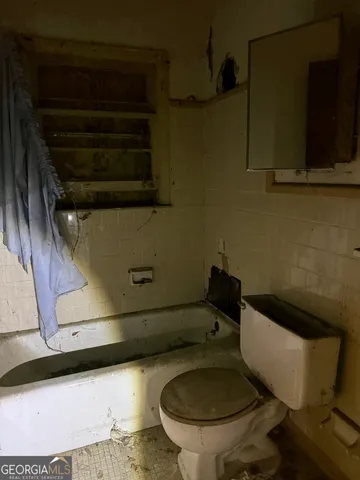 a toilet sitting in a bathroom next to a sink