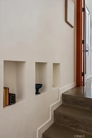 a bedroom with a bed and potted plants next to a window