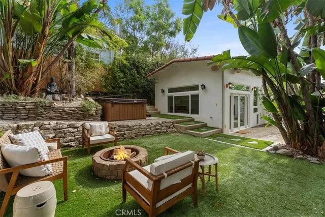 a view of a backyard with table and chairs potted plants and a palm tree