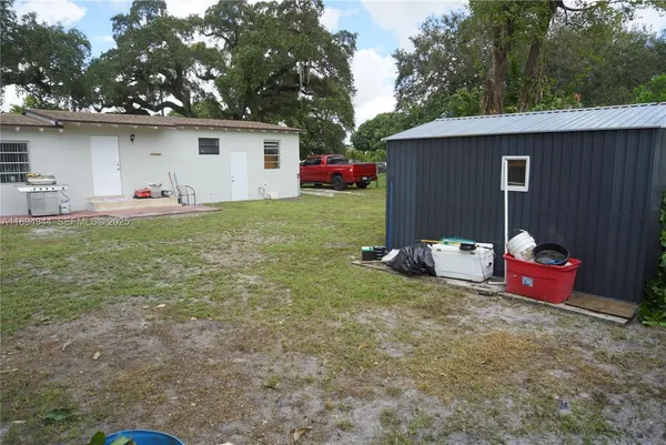 a backyard of a house with plants and large trees
