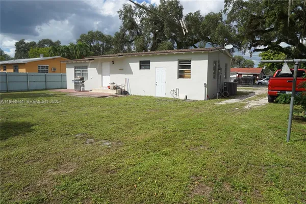 a view of a house with backyard and trees