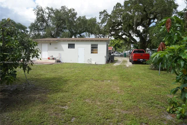 a view of a house with backyard and sitting area