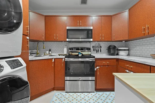 a kitchen with stainless steel appliances a stove a sink and a microwave