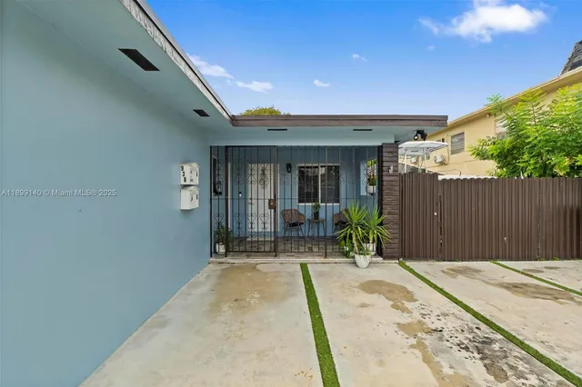 a front view of a house with a glass door and furniture