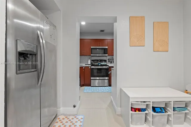 a hallway with cabinets and stainless steel appliances