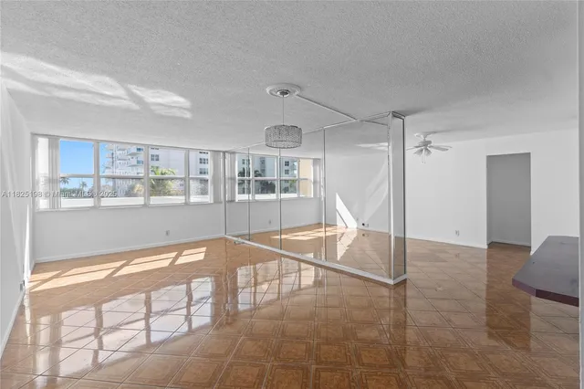 a view of a livingroom with wooden floor and a kitchen space