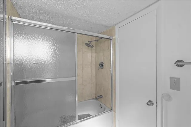 a bathroom with a granite countertop sink a mirror and shower