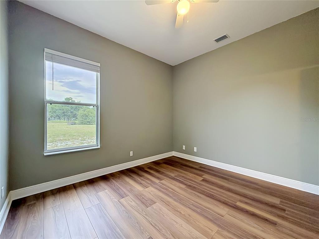 28549 Shirley Shores Road Tavares, FL 32778 - Photo 39 of 65 an empty room with wooden floor and windows