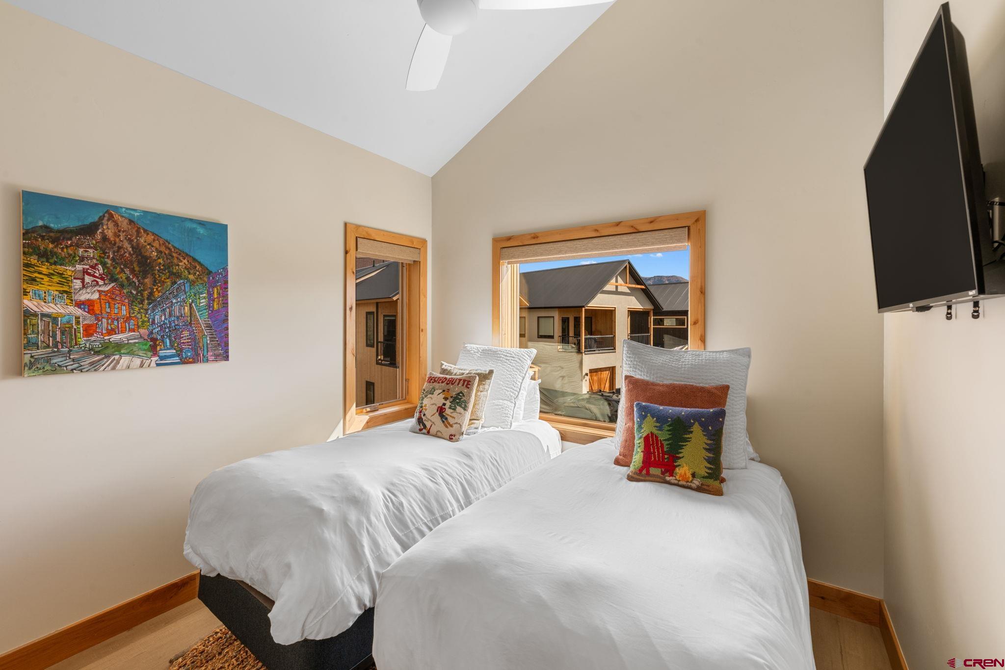 101 Elk Valley Road, Unit D Crested Butte, CO 81224 - Photo 26 of 37 a bedroom with a bed and a flat screen tv