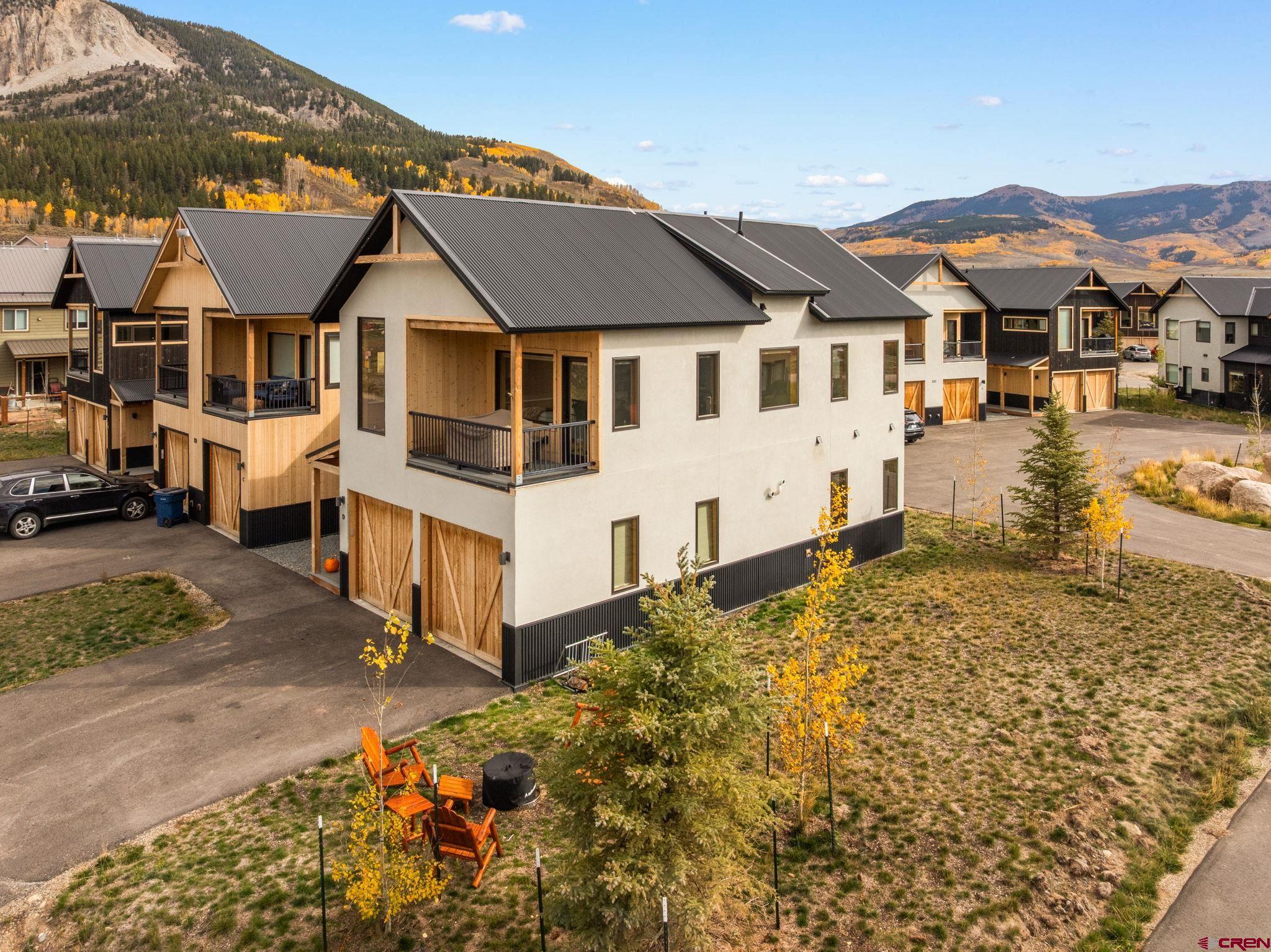 101 Elk Valley Road, Unit D Crested Butte, CO 81224 - Photo 34 of 37 a view of a white house next to a road with a building in the background