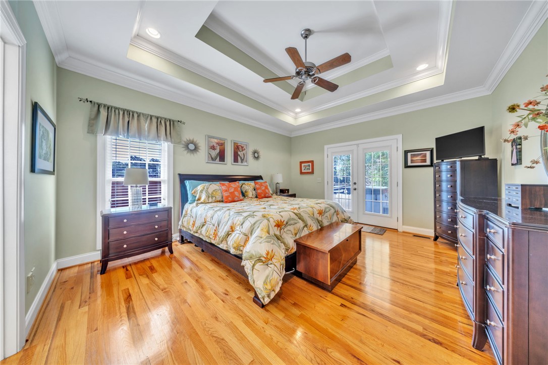 648 Mountain View Road Williamston, SC 29697 - Photo 17 of 42 Hardwood floors and a tray ceiling with a fan define this inviting primary bedroom retreat.