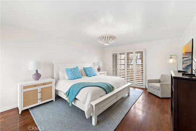 a spacious bedroom with a bed and wooden floor