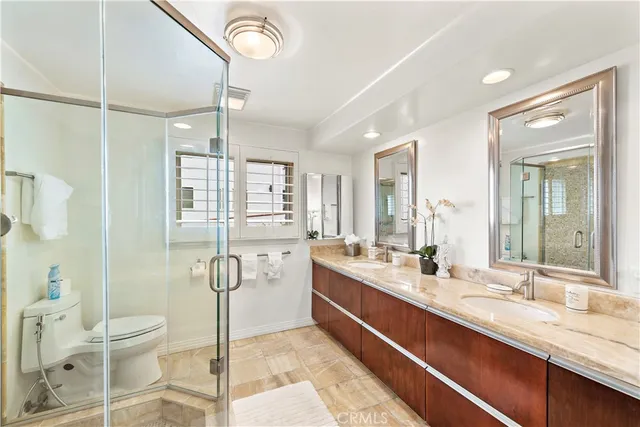 a bathroom with a double vanity sink toilet mirror and bathtub