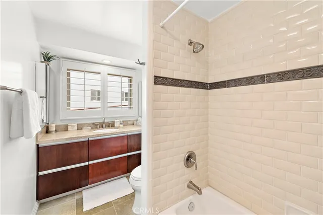 a bathroom with a sink and mirror with bathtub