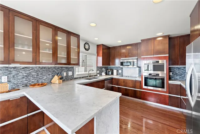 a kitchen with stainless steel appliances granite countertop a sink and a stove