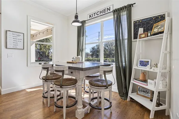 a dining room with furniture a chandelier and wooden floor