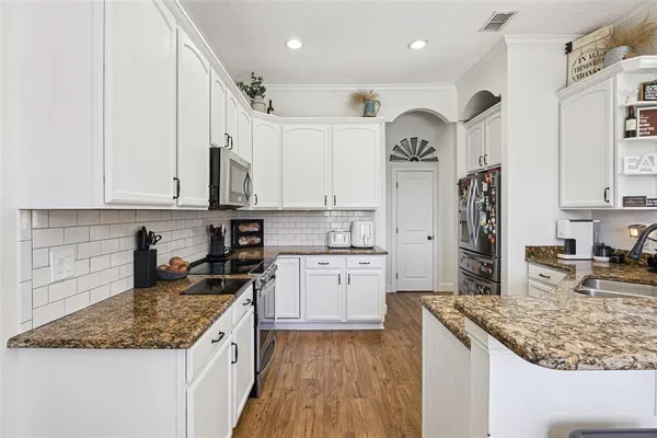 a kitchen with stainless steel appliances granite countertop a sink stove and refrigerator