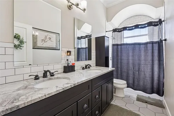 a bathroom with a granite countertop sink mirror vanity and toilet