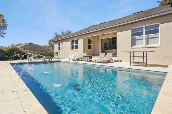 a swimming pool with outdoor seating and yard