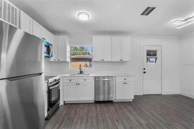 a kitchen with stainless steel appliances a refrigerator sink and microwave
