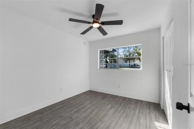 a view of empty room with wooden floor