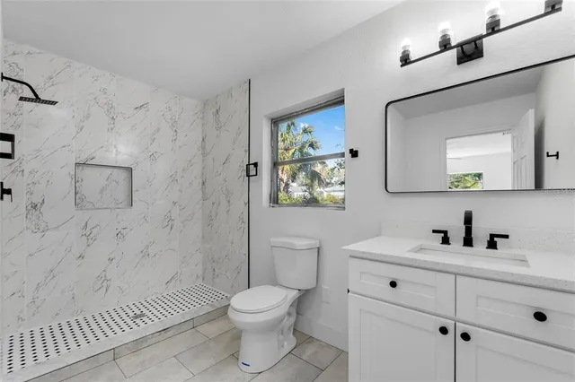 a bathroom with a toilet sink vanity and mirror