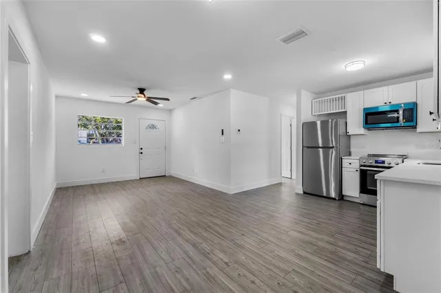 a view of a kitchen with a sink a refrigerator and a stove top oven