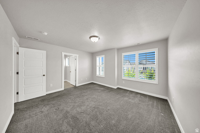 7817 West Kings Top Road Magna, UT 84044 - Photo 15 of 29 Primary Bedroom Spacious room featuring gray carpeting, light gray walls, white trim, and multiple windows with white plantation shutters