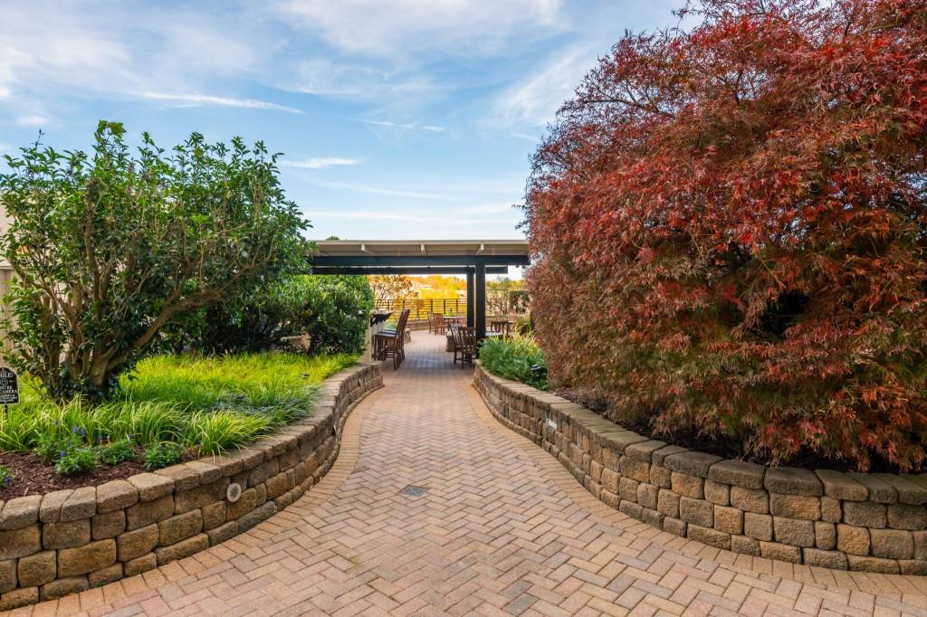 4561 Olde Perimeter Way, Unit 1701 Atlanta, GA 30346 - Photo 48 of 64 a view of a pathway with a bench in front of house