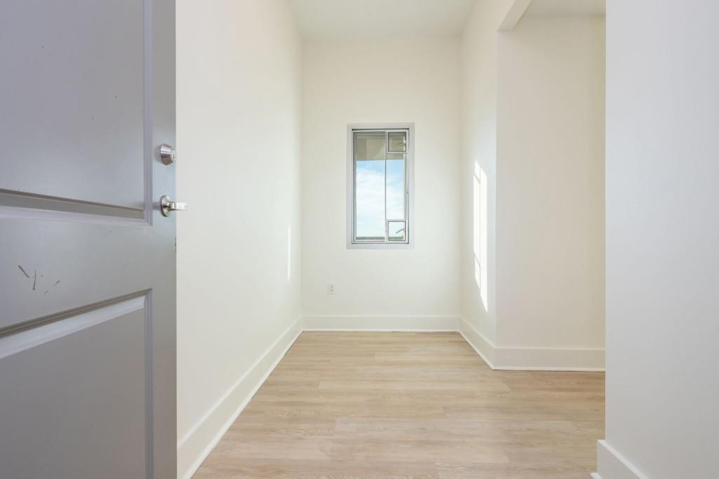 4561 Olde Perimeter Way, Unit 1701 Atlanta, GA 30346 - Photo 5 of 64 a view of an empty room with wooden floor and a window