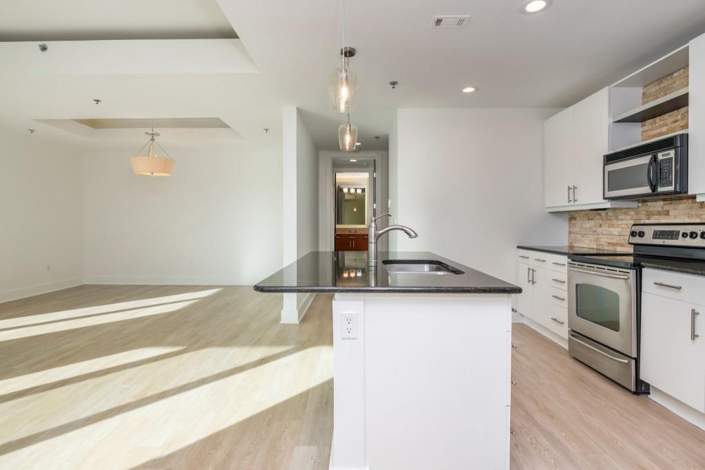 4561 Olde Perimeter Way, Unit 1701 Atlanta, GA 30346 - Photo 6 of 64 a kitchen with granite countertop a sink and a stove top oven
