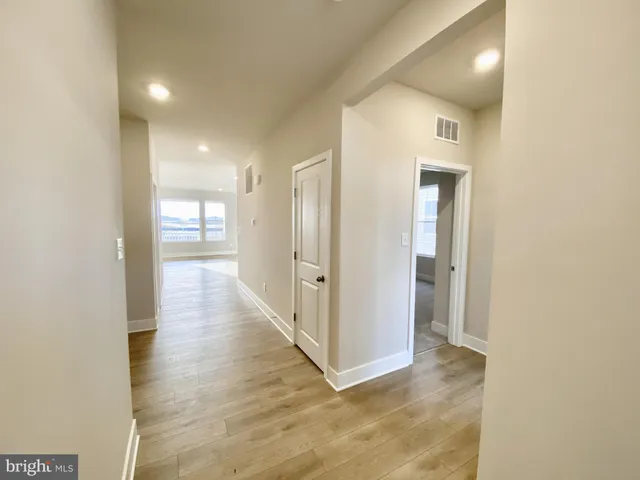 a view of a hallway with wooden floor